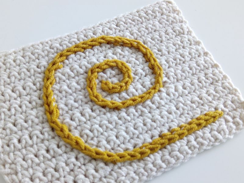 a crocheted block with an overlay motif