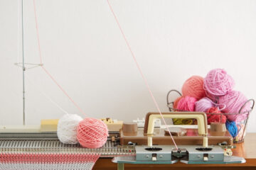 A table with a sewing machine and the best yarn for knitting machine.