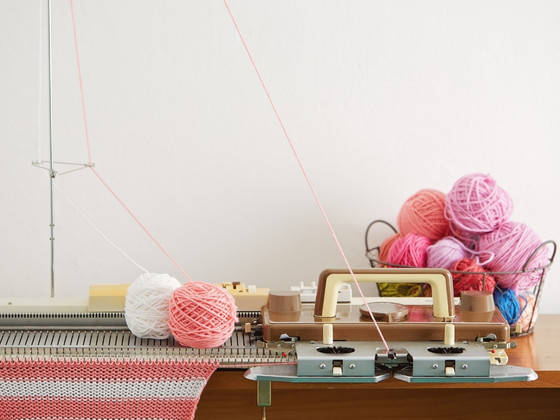 A table with a sewing machine and the best yarn for knitting machine.