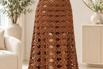 Cocoa brown crochet maxi dress with oval lace pattern displayed on dress form showing fitted bodice and flared skirt